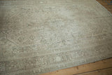 Machine bound edge of distressed Tabriz design rug, showing subtle platinum and beige motifs.