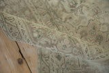 Vintage distressed rug's rolled pile, showing even knot wear, faint foundation, and muted tones.
