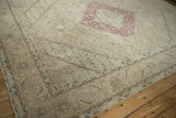 Distressed beige field with Herati motifs and partial raspberry red medallion.