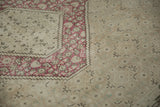 Distressed vintage Turkish Tabriz rug detail: raspberry red border with subtle beige field motifs.
