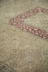 Distressed raspberry red stepped motif and subtle neutral patterns on a vintage Turkish Tabriz rug.