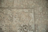 Distressed vintage Turkish Tabriz rug close-up: textured pile, serrated leaf border, soft ivory and blue.