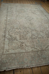 Distressed Turkish Tabriz carpet with worn ivory pile and dusty powder blue blossoms.