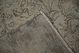 Distressed vintage Turkish Tabriz rug pile showing wear, exposed hand-knotted foundation, and machine-bound side.