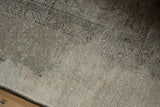 Distressed vintage Turkish Tabriz design carpet showing worn pile and exposed foundation texture in neutral tones.