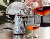 A Disco Mushroom decorative object covered in a mosaic of reflective silver mirror tiles.