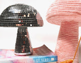 Disco mushroom decor with reflective tiles shown next to a pink mushroom.