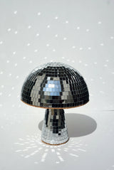 Disco Mushroom casting a speckled light pattern from its mirrored surface.