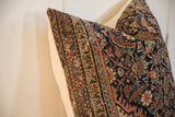 Detailed corner view of antique Persian Fereghan pillow fragment, showing navy and rust patterns.