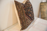 Edge detail of the hand-knotted Persian Fereghan pillow, revealing navy, red, and gold patterns.
