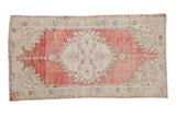 Distressed Oushak runner with an ivory medallion and spandrels over an abrashed, faded red field.