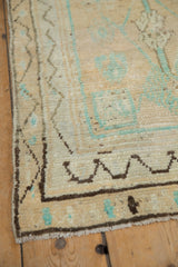 Low pile and knot heads on a vintage Oushak corner with a meandering chocolate brown vine border.