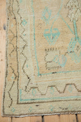 Restored side cord and meandering vine border on a vintage distressed Oushak rug corner.
