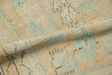 Storied texture and low pile of a distressed Oushak rug in soft cream and mint green.