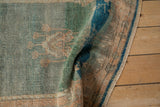 A close view of the vintage Oushak's soft wool pile, showing jade and sandalwood color abrashes.