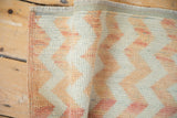 Textured pile of a distressed Oushak rug with chevron stripes and side binding.