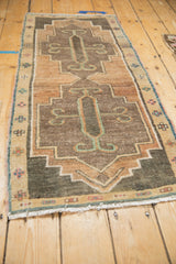Vintage Kars runner's fringed end, showing narrow border with dusty teal and pink motifs.