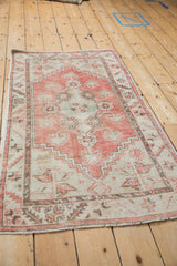 Distressed Oushak runner's finned blossoms and serrated leaf border in pale red, seafoam.