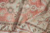 Distressed pile of the vintage Oushak runner, revealing pale red, seafoam green, and antique ivory tones.