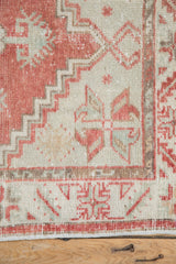 Distressed blush and ivory Oushak rug border with serrated leaf motif and wear.