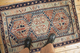 Vintage Anatolian rug with geometric gul medallions, time-softened terracotta, ivory, and navy hues.