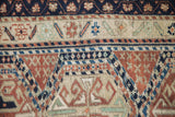 Vintage Anatolian rug pile featuring geometric germinating blossoms in navy, terracotta, and jade.
