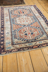 Geometric blossoms and leaf border in terracotta, ivory, and navy on a vintage Anatolian rug.