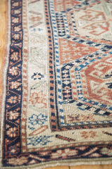Navy blue floral main border of the Anatolian rug with terracotta geometric field.