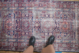 Standing view of a vintage Anatolian rug, highlighting its low-pile texture and geometric medallion design.