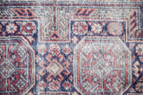 Hand-knotted weave showing mostly even wear across the geometric pomegranate and serpent borders.
