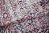 A soft fold in the vintage Anatolian rug displays the low, textured pile and hand-knotted weave.