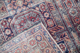 Folded corner of the vintage Anatolian runner showing the geometric border, side selvage, and weave.