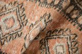 Close-up showing the evenly worn, low-pile texture of the distressed Oushak rug.