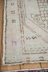 Distressed vintage Oushak rug, showing chocolate brown side selvage and subtle ivory, seafoam wear.