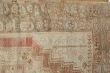 Worn Anatolian rug pile with faded blush, ivory, and serrated border details.