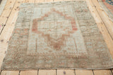 Distressed Anatolian rug corner detail: dusty blush tree of life, serrated border, fringe.