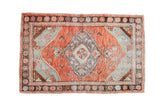 Vintage distressed Oushak rug with brick red-orange medallion, seafoam, and charcoal patterns.