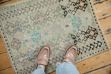 A distressed Oushak rug mat showing its soft, low-pile texture and scale underfoot.