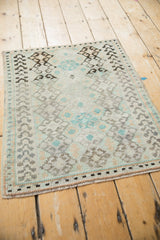 Angled view of a vintage Oushak mat highlighting its tiered geometric patterns.