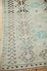 Corner view showing the geometric border and low pile texture of a vintage Oushak rug.