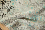 A soft drape reveals the evenly worn, hand-knotted pile of a vintage distressed Oushak rug.