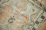 Distressed Oushak runner texture, showing beige, seafoam, and faded terracotta geometric motifs.