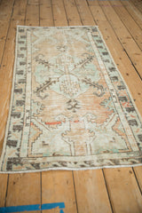 Close-up of distressed Vintage Oushak rug, showing worn pile texture in beige, seafoam green.