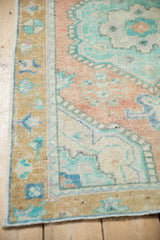 Distressed vintage Oushak rug with shaded deep gold border, germinating plants, and even wear.