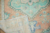 Hand-knotted foundation and distressed pile of Vintage Oushak rug, showing mint and peach tones.