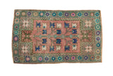 Distressed vintage Oushak rug with dusty blush tree of life and sage green starburst border.