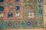 Vintage distressed Oushak corner with starburst floral border, dusty blush and aqua green.