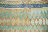 Detail of the zig-zag border and diamond-shaped medallions on a hand-knotted distressed Oushak rug.