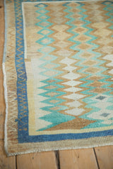 Detail of the distressed pile and denim blue border on a vintage Oushak rug.