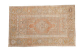 Vintage distressed Oushak rug with a stepped medallion and floral border in muted sandalwood, gold, and silver hues.